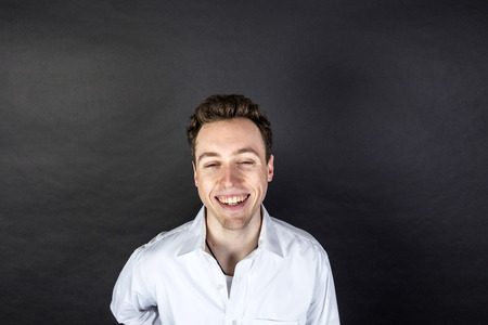 portrait of laughing young man  isolated on blackの写真素材