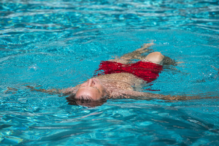 man enjoys swimming in the outdoor swimming poolの写真素材