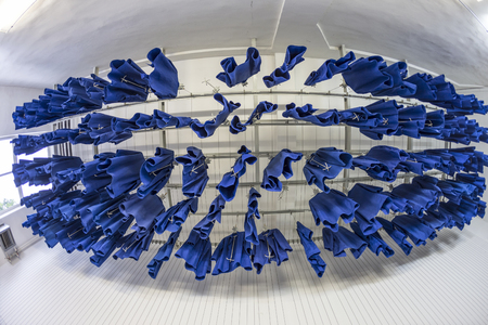 blue workers clothes hanging at the ceiling in a mining plantの写真素材