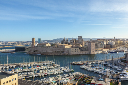 MARSEILLES; FRANCE - MAR 29, 2015: facade of old historic castle and the promenade with sailing boats in the harbor.のeditorial素材