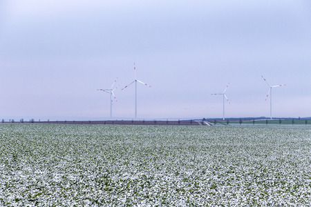 wind generators in winter landscape on a foggy dayの写真素材
