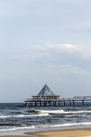 HERINGSDORF, GERMANY - APRIL 20, 2014: people enjoy pier and beach of Heringsdorf, Germany. The shops at the pier offer food and clothes.のeditorial素材