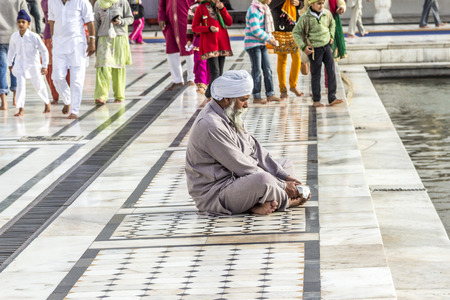 AMRITSAR, INDIA - FEB 24, 2013: people pray in the   Harimandir Sahib at the Golden temple complex, Amritsar - Indiaのeditorial素材