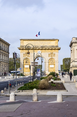 MONTPELLIER, FRANCE - MAR 31, 2017: Arc de Triumphe in Montpellier, dating from 1692, with surrounding buildings, people and traffic signs.のeditorial素材