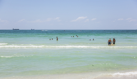 MIAMI BEACH, FLORIDA - JULY 27, 2010: Tourists sunbath, swim and play on South Beach in Miami Beach, Florida, USA.のeditorial素材