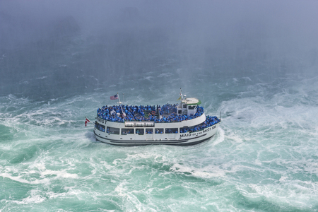 The boat with tourists eager to see the nature miracle in front of Niagara Bridal Veil Falls.の写真素材