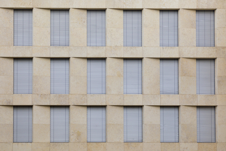 facade of generic office building with closed shutter blindsの写真素材