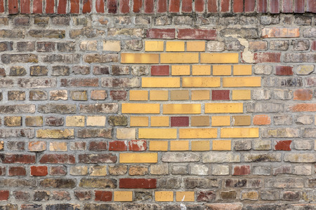 old brick wall repaired with newer bricksの写真素材