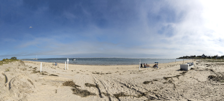 CHATHAM, USA - SEP 24, 2017: people enjoy the scenic beach at island Cape Cod with pier and sailing boat at Chatham, USAのeditorial素材