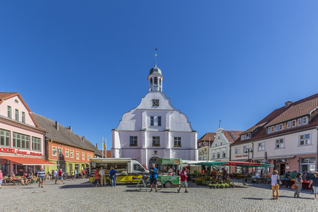 WOLGAST, GERMANY - AUG 13, 2015: people enjoy gothic St Petri church in Wolgast under blue sky with historic market place.のeditorial素材
