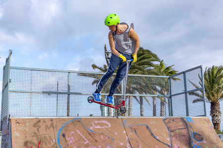 ARRECIFE, SPAIN - JAN 18, 2018: teenage boy jumping at the skate park over a ramp. The skate park is painted with grafitty by young people.のeditorial素材