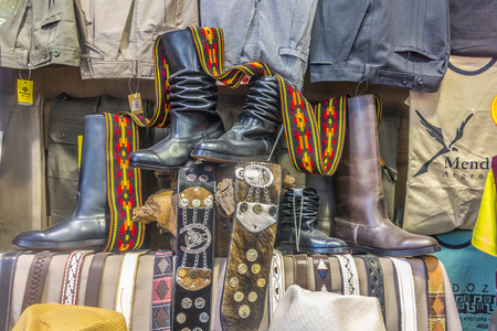 MENDOZA, ARGENTINA - FEB 13, 2018:  cowboy boots and equipment in a shop in Mendoza, Argentina. Boots and clothes are in typical argentina cowboy style.のeditorial素材