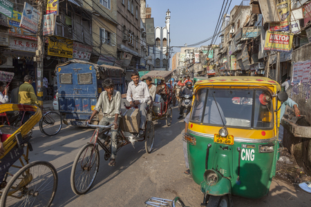 NEW DELHI, INDIA - NOV 17, 2011: man carries  cargo and people with his rickshaw  in old Delhi, Chawri Bazaar.のeditorial素材