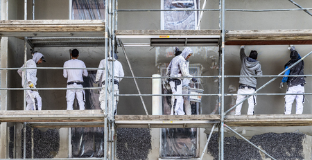FRANKFURT, GERMANY - SEP 26, 2018:  painter and plasterer work on a scaffold to renovate an old...