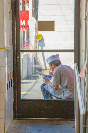Los Angeles, USA - JULY 6, 2008:  a chinese cook in chinatown enjoys his lunch in the backyard of the restaurant.のeditorial素材
