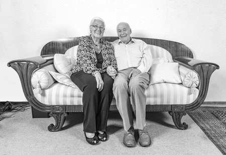 caucasian senior  couple in love sitting on a sofaの写真素材