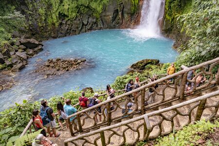TENORIO, COSTA RICA - MAR 1, 2019: tourists watch from a platform the scenic waterfall in tenorio volcano national park, Costa Rica.のeditorial素材