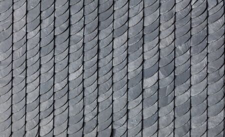 detail of grey slate roofing in historical pattern