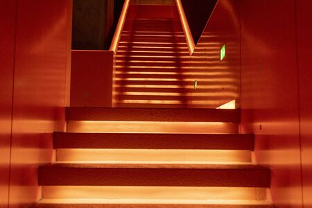 Essen, Germany - July 23, 2019:  Interior view of beautiful orange illuminated remarkable staircase is located at the entrance of Ruhr museum at Zeche Zollverein, Zollverein Coal Mine Industrial Complex.のeditorial素材
