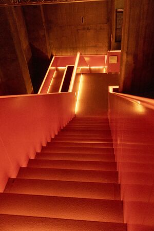 Essen, Germany - July 23, 2019:  Interior view of beautiful orange illuminated remarkable staircase is located at the entrance of Ruhr museum at Zeche Zollverein, Zollverein Coal Mine Industrial Complex.のeditorial素材