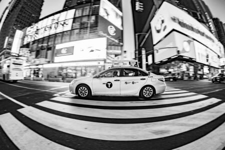 New York, USA - October 7, 2017: taxi driver with passengers crosses a pedestrian crossing at times square. Times square is a symbol for New York life and amusement.のeditorial素材