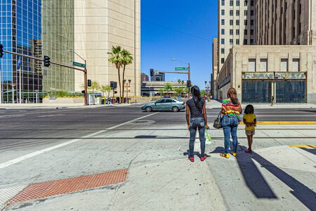 Phoenix, USA - June 14, 2012: new modern skyscraper in downtown Phoenix, USA with people crossing a street.のeditorial素材