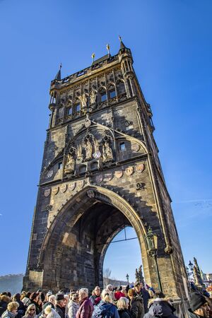Prague, Czech Republic - January 1, 2020: people passing the old huge gate at   Charles bridge.のeditorial素材