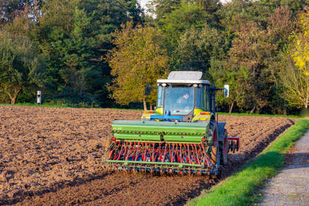 Schwalbach, Germany - October 19, 2014: farmer plows his field with a plowing machine in spring time.のeditorial素材