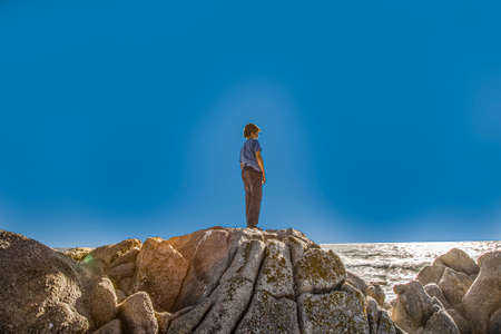 boy overlooks the scenic rocky coast in Monterey in sunsetの写真素材