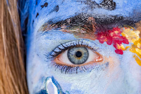detail of eye in blue painted colorful female face