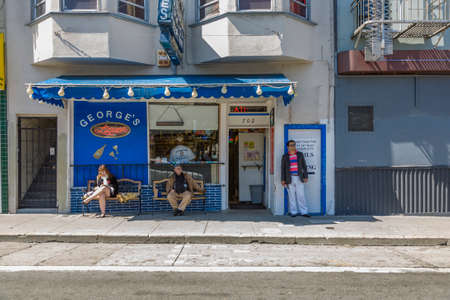San Francisco, USA - July 23, 2008:  two man and a woman at a bench waiting in front of a bar for...