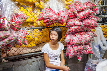 Bangkok, Thailand - May 12, 2009: woman sells flowers at the nightly flower market Pak Klong Thalat in Bangkok.のeditorial素材