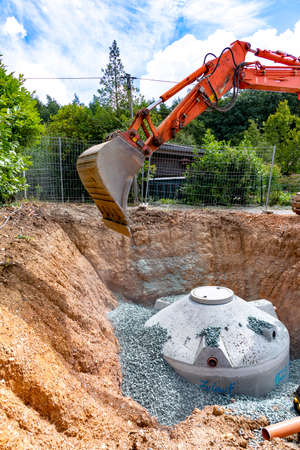 Construction site with cistern made of cement filled with gravel by a craneの写真素材