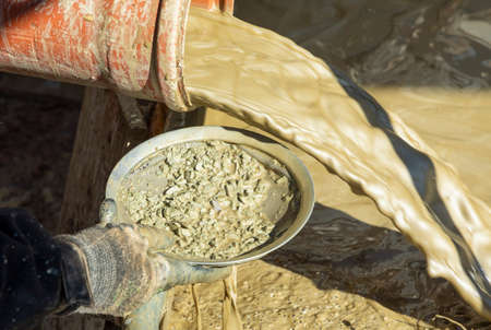 water mixed with loam from an artificial fountain drilling machine and stones checked by hand with a...