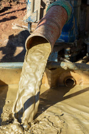water mixed with loam from a drilling hole from an artificial fountain drilling machine