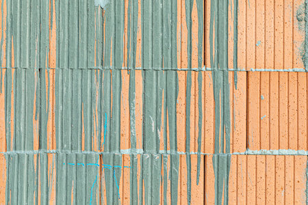 background of red brick with dried flowing concrete pattern as symbol for construction site
