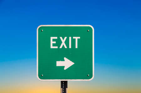 green exit sign under clear blue skyの写真素材