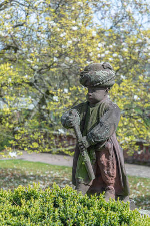 Frankfurt, Germany - April 24, 2021: old sandstone figures showing young arabic musicians in style of the 18th century in the park of the Bolongaro building in Frankfurt Hoechst.のeditorial素材