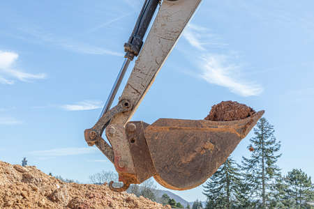 detail of excavator bucket filled with soil under blue skyの写真素材