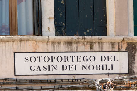 signage  Sotoportego del Casin dei Nobili (english: passage to place of the nobles) in Venice at an old grunge house wallの写真素材