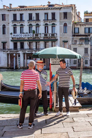 Venice, Italy - July 7, 2021: Gondolier waiting at the gondola stop for passengers in Venice, Italy.のeditorial素材