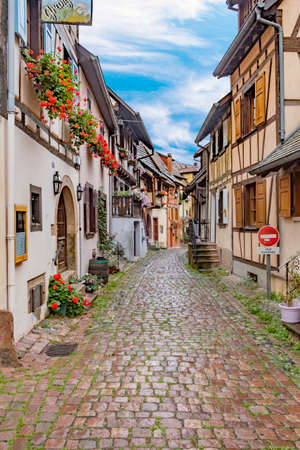 Eguisheim, France - October 4, 2021: scenic small road with half timbered houses in the historic village of Eguisheim in the Alsace region in France.のeditorial素材