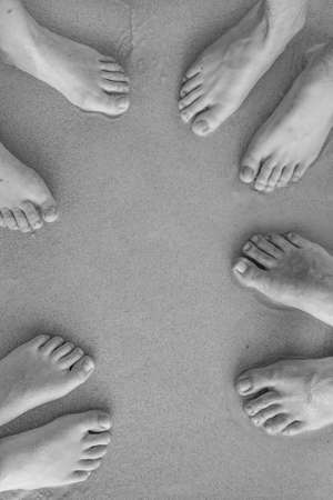 feet of the family, father, mother and two suns at the sandy beach