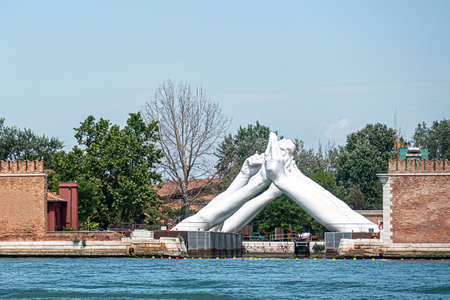 Venice, Italy - July 1, 2021: Venice, Italy Venice Biennale, Lorenzo Quinn - Building Bridges hands sculpture.のeditorial素材