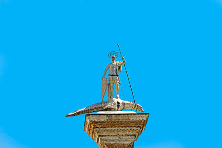 Close-up of St. Theodore's Column in St. Mark's Square with blue sunny sky. At the city of Venice, the historic and amazing marine city. Located in Veneto region, northern Italyの写真素材