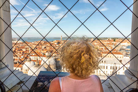 woman enjoys scenic view to roof of san marco cathedral and skyline of Venice, Italyの写真素材