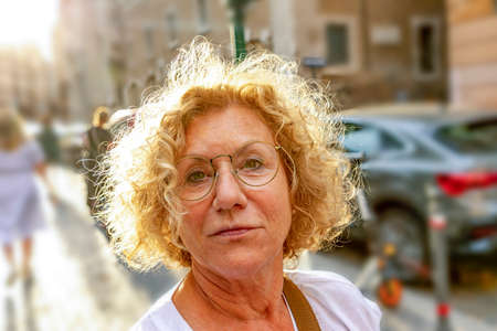 portrait of attractive handsome causcasian woman in sunset in summer with curly blonde hair