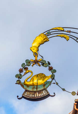Rothenburg ob der Tauber, Germany - January 15, 2014: Medieval shop sign of a restaurant in Rothenburg ob der Tauber under blue sky.のeditorial素材