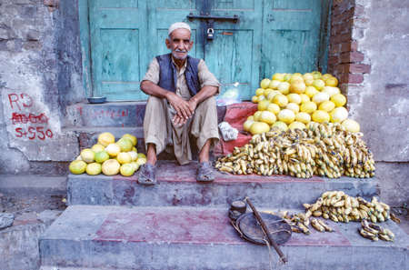 Peshawar, Pakistan - June 30, 1987: old man selling bananas and fruits at the market in Peshawar.のeditorial素材