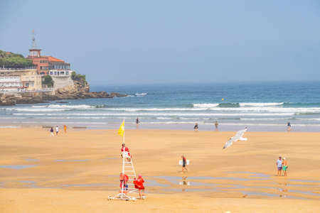 Gijon, Asturias, Spain - September 18, 2018: people relax at the San Lorenzo beach in Gijon with view to historic town.のeditorial素材